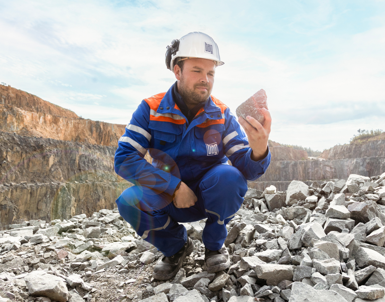 BAG-Mitarbeiter hält Gestein in der Hand im Steinbruch.