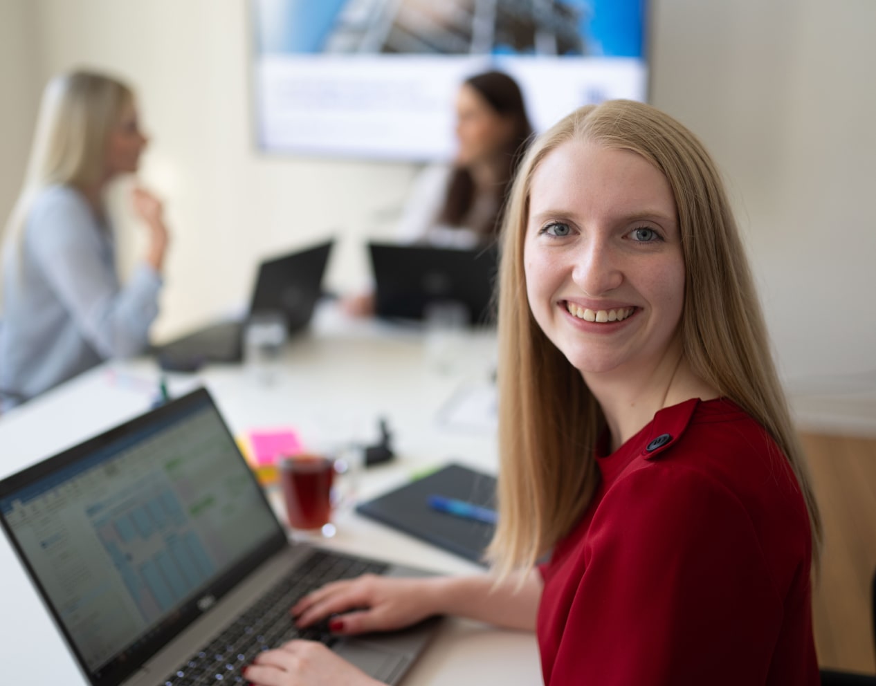 Trainee mit Laptop auf einer Parkbank.