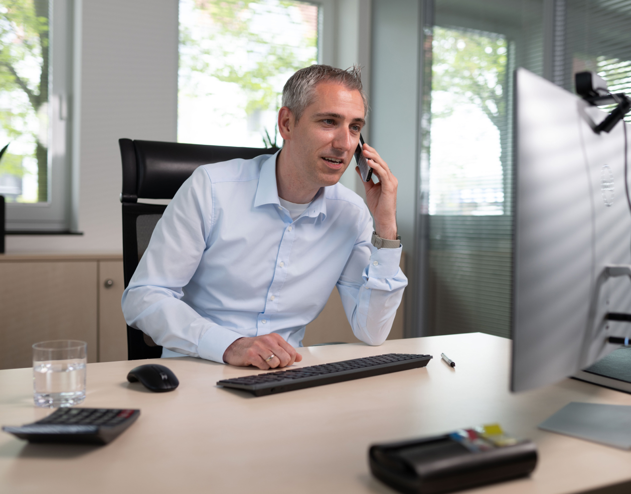 Vertriebsmitarbeiter führt Telefonat im Büro, um Geschäftsaktivitäten zu koordinieren.